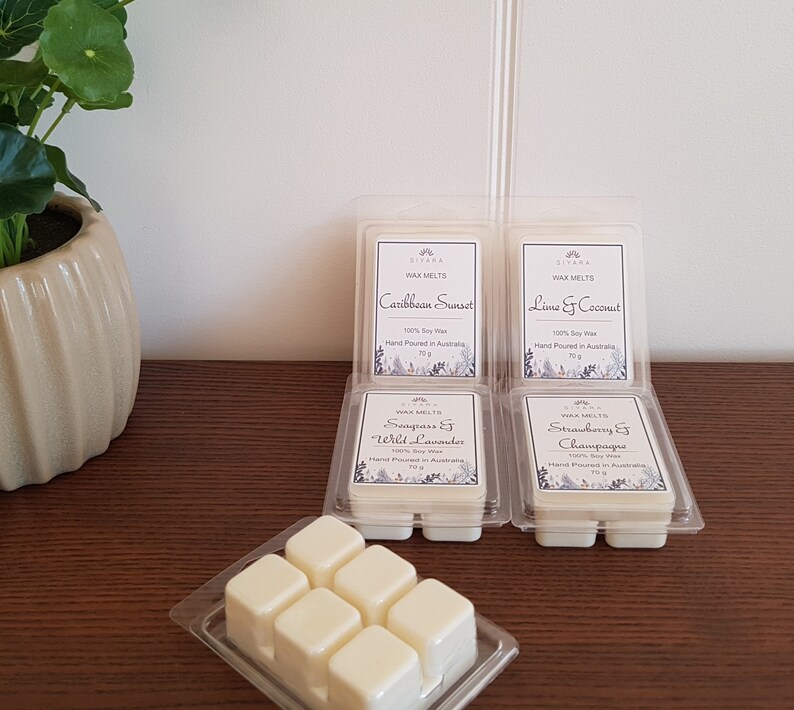 K&ouml;nnte beinhalten: Sechs Wachsschmelzen in durchsichtigen Plastikbeh&auml;ltern mit Etiketten. Die Etiketten sind wei&szlig; mit schwarzem Text und zeigen verschiedene D&uuml;fte: Caribbean Sunset, Lime & Coconut, Seagrass & Wild Lavender, Strawberry & Champagne. Die Wachsschmelzen sind handgefertigt in Australien und bestehen aus 100% Sojawachs.