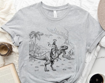 Jesus Riding Dinosaur Graphic T-Shirt: Funny Novelty Tee