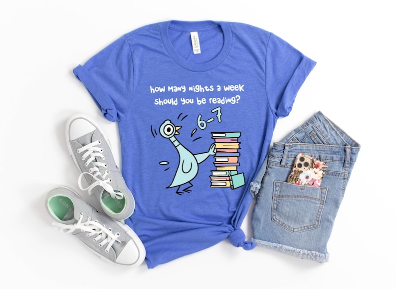 K&ouml;nnte beinhalten: Blaues T-Shirt mit einem Cartoon-Tauben-Motiv, das B&uuml;cher h&auml;lt, und dem Text "Wie viele N&auml;chte pro Woche solltest du lesen?" mit der Antwort "6-7". Graue Turnschuhe und Jeansshorts sind ebenfalls zu sehen.