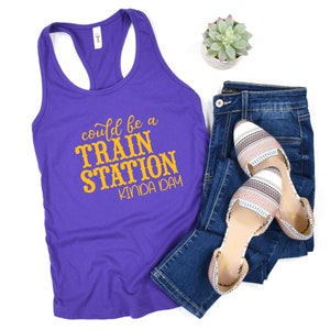 May include: Purple tank top with a yellow graphic that says "could be a train station kinda day".