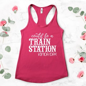May include: Pink tank top with white text that reads "could be a TRAIN STATION kinda day".