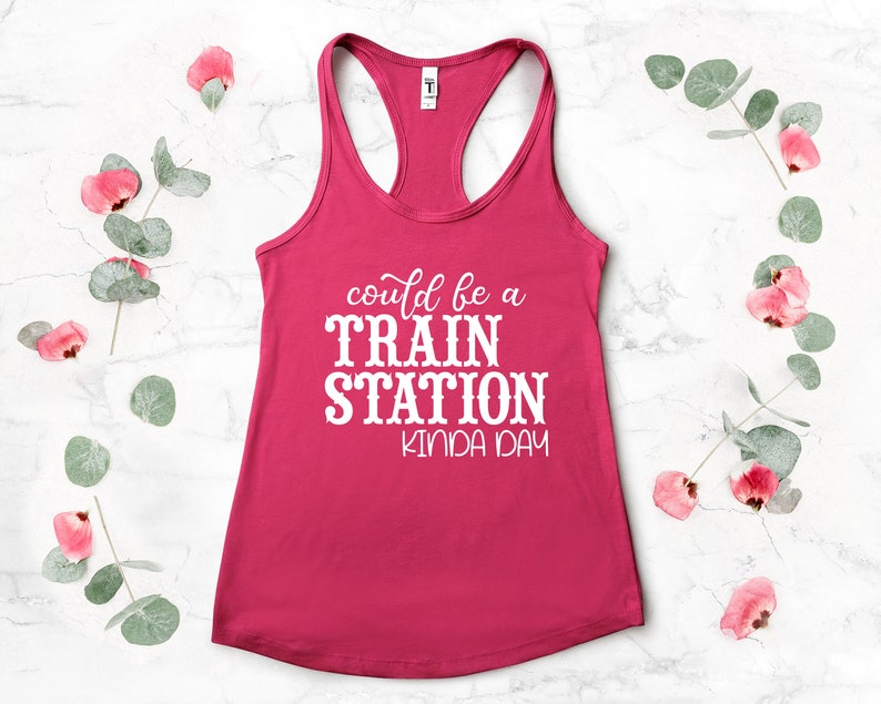 May include: Pink tank top with white text that reads "could be a TRAIN STATION kinda day".
