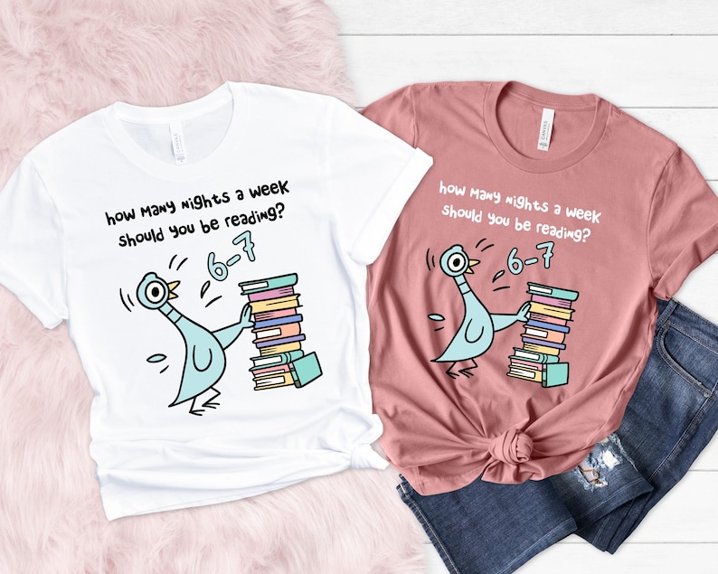 K&ouml;nnte beinhalten: Zwei T-Shirts, eines wei&szlig; und eines rosa, mit einer Cartoon-Taube, die B&uuml;cher h&auml;lt. Der Text lautet: &bdquo;Wie viele N&auml;chte pro Woche solltest du lesen? 6-7&ldquo;.