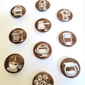 May include: Ten brown round buttons with white coffee-themed icons. The icons include a coffee cup, a coffee pot, a coffee bean, a french press, a milk carton, an espresso machine, a moka pot, a to-go coffee cup, and a coffee cup with steam.
