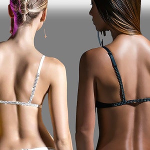 May include: Two women wearing different styles of black and white lingerie with jeweled straps. The straps are adorned with rhinestones.