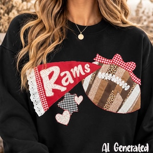 May include: A black sweatshirt featuring a red pennant with the white text "Rams" and a decorative football-shaped applique. The design includes a red and white gingham bow, two small hearts, and various fabric patterns including leopard print.