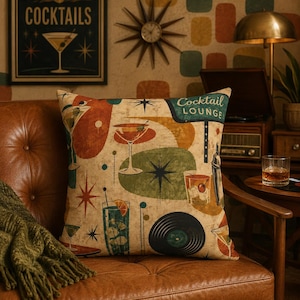 May include: A square throw pillow featuring a beige background with a mid-century graphic print of various cocktails, a vinyl record, and the text Cocktail Lounge. The design includes abstract shapes in red, green, and orange with starburst accents.
