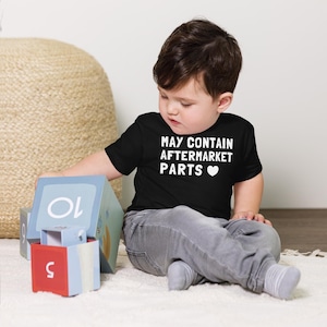 Camiseta infantil de manga curta com estampa divertida de peças de reposição: substituição articular, transplante e marca-passo.