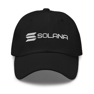 Può includere: Cappellino da baseball nero con testo e logo "SOLANA" ricamati in bianco. Il logo presenta tre linee orizzontali. Il cappellino ha una visiera curva e un bottone sulla parte superiore. Un accessorio elegante.