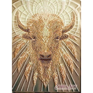 Peut inclure: Œuvre d'art perlée détaillée représentant une tête de bison avec un motif attrape-rêves. L'œuvre utilise des perles dorées, marron et crème. Des plumes et des motifs géométriques entourent le bison. L'image comprend le texte "ABRIS ART".
