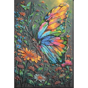 May include: A colorful beaded butterfly with orange, yellow, blue, and green wings is the focal point of this artwork. The butterfly is surrounded by beaded flowers and foliage in shades of orange, blue, and green, set against a dark gray background.