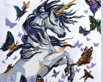 May include: A white unicorn with a gold horn and a purple mane and tail is surrounded by colorful butterflies. The unicorn is standing on its hind legs with its front legs raised in the air. The butterflies are flying around the unicorn and some are landing on its body.
