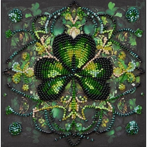 May include: A green four-leaf clover beaded design with a black background. The clover is surrounded by a decorative border of green, black, and gold beads.