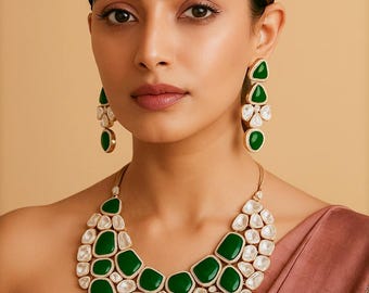 May include: A green and white gemstone necklace and matching earrings set. The necklace features large, emerald-green stones interspersed with white, irregular-shaped stones, all set in a gold-colored metal. The earrings have a similar design, with green and white stones.