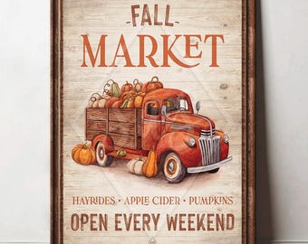 May include: A framed print featuring a vintage red truck filled with pumpkins. The words "FALL MARKET" are displayed above the truck, with "HAYRIDES • APPLE CIDER • PUMPKINS" and "OPEN EVERY WEEKEND" below. The artwork has a rustic, autumnal theme.