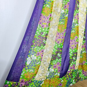 Könnte beinhalten: Ein Rock mit floralem Muster in Lila, Grün und Weiß mit einem weißen Spitzenbesatz. Der Rock ist aus einem leichten Stoff gefertigt und hat eine fließende Silhouette.