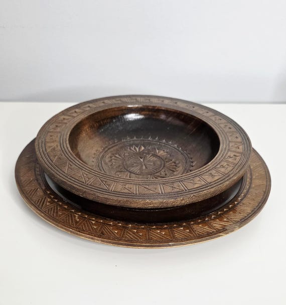 A hand-carved wooden bowl and charger plate duo with genuine vintage character — the kind of tactile, one-of-a-kind piece that makes a tablescape or shelf look like it was curated over decades.