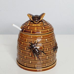 Tarro de miel vintage con tapa y cuchara.