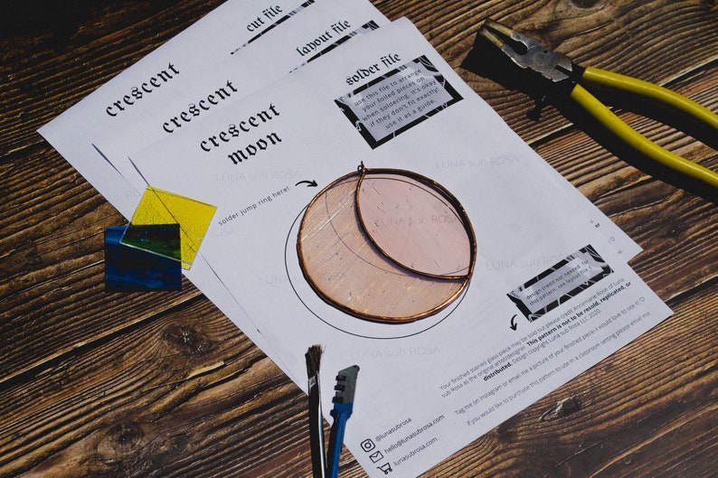 May include: A white paper template with instructions for making a crescent moon stained glass project. The template includes a diagram of the moon shape, a solder jump ring, and the text "crescent moon".