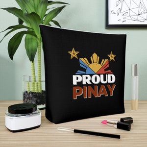 May include: Black zippered pouch with a white zipper. The pouch has a graphic of the Philippine flag with the words "Proud Pinay" in red, white, and blue.