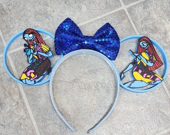 May include: Blue headband with a blue sparkly bow and two blue ears with a cartoon image of Sally from the Nightmare Before Christmas on each ear.