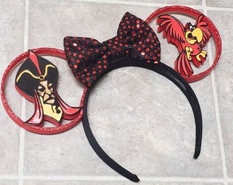 May include: Red and black Minnie Mouse ears with a black bow and a red parrot and Jafar from Aladdin on the ears.