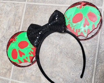 May include: Black headband with a black sequined bow and two red and green apple ears with a skull design.