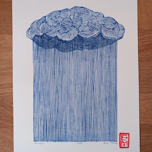 Op de afbeelding: Een blauw-witte linosnede die een gestileerde regenwolk afbeeldt. De wolk is gedetailleerd met wervelende lijnen en de regen valt in verticale lijnen. De prent staat op wit papier, met tekst en een rode stempel in de rechter benedenhoek.