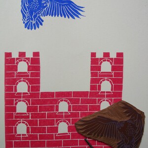 May include: A red brick castle with five arched windows and a brown wooden carving of an owl with outstretched wings. The carving is used to create a print of the owl.