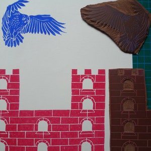 May include: A set of three woodblock printing stamps. The stamps are used to create a castle scene with a red brick wall and arched windows. The third stamp is a brown bird with outstretched wings.