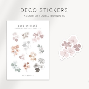 May include: A sheet of stickers featuring various floral bouquets in shades of brown, pink, and grey. The stickers are labelled "Deco Stickers, Assorted Floral Bouquets, Daisy Papers".