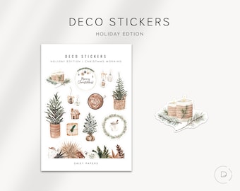 May include: A sheet of stickers with a Christmas theme. The stickers feature illustrations of candles, trees, wreaths, and other festive elements. The stickers are designed in a watercolour style with a rustic aesthetic. The text "DECO STICKERS HOLIDAY EDITION CHRISTMAS MORNING" is printed at the top of the sheet.