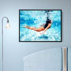 May include: A watercolor painting of a person swimming underwater in a pool. The person is wearing a black swimsuit and is floating on their back. The water is a light blue color and there are white waves.