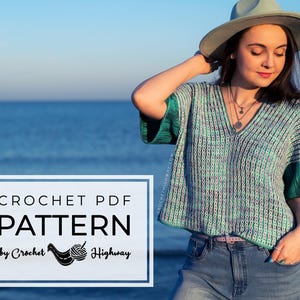 May include: A woman wearing a turquoise and green crochet top with a V-neck and flared sleeves, paired with blue jeans and a hat. The image includes text that reads "CROCHET PDF PATTERN by Crochet Highway". The background is the ocean.