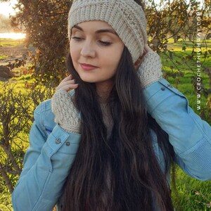 May include: A woman wearing a beige crocheted ear warmer headband and matching fingerless gloves. The headband has a criss-cross pattern and the gloves have a simple stitch.