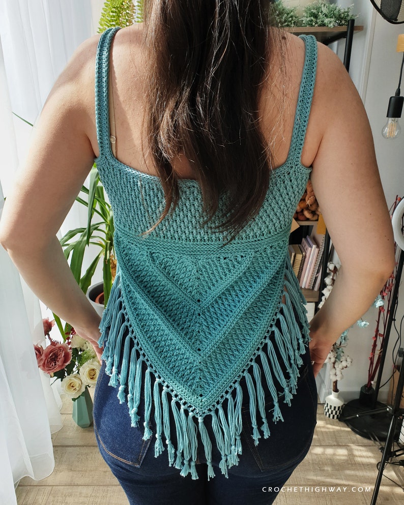 Puede incluir: Un top de crochet de color turquesa con un dise&ntilde;o triangular y ribete de flecos. El top es sin mangas y tiene un escote cuadrado.