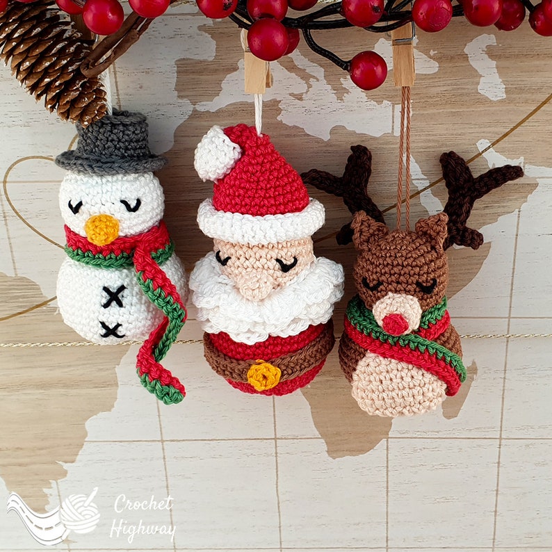 Peut inclure: Trois d&eacute;corations de No&euml;l en crochet&nbsp;: un bonhomme de neige avec une &eacute;charpe verte et des boutons noirs, le P&egrave;re No&euml;l avec un chapeau rouge et une barbe blanche, et un renne avec des bois bruns et une &eacute;charpe verte.