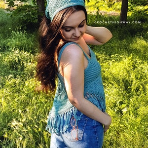 Puede incluir: Una mujer lleva una blusa de crochet azul con detalles de flecos y una bandana de crochet azul. Lleva unos vaqueros azules con un par de gafas bordadas en el bolsillo trasero. La foto fue tomada al aire libre en una zona cubierta de hierba.