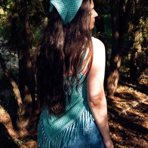Puede incluir: Un top de crochet de color turquesa con detalles de flecos. El top se lleva con jeans azules y un pa&ntilde;uelo de crochet turquesa a juego.