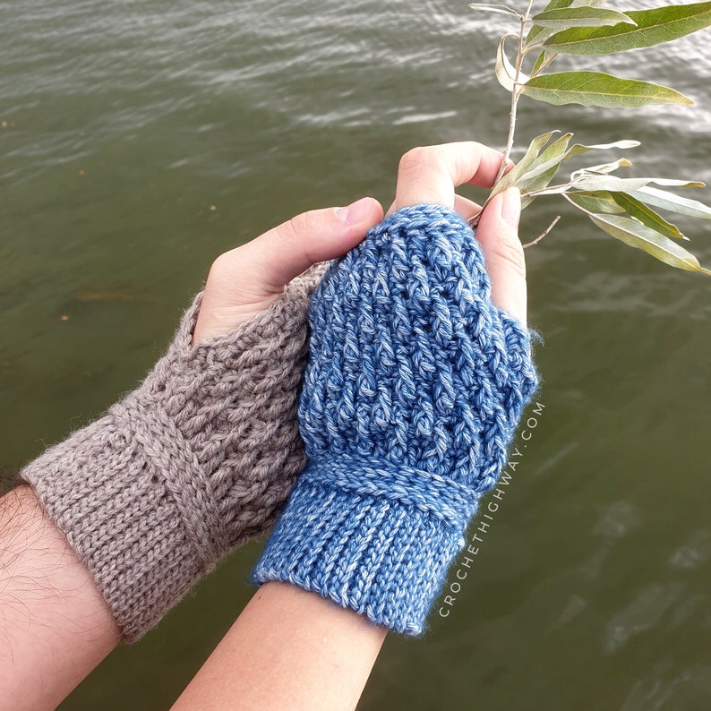 May include: Two pairs of crocheted fingerless gloves, one in a light blue colour and one in a light brown colour. The gloves are shown on a person's hands against a blurry background of water.