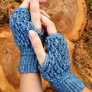 May include: A pair of blue crocheted fingerless gloves with a textured stitch pattern. The gloves are shown on a person's hands.