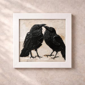 May include: A framed artwork featuring two black crows facing each other. The crows are painted with thick brushstrokes on a textured, off-white background. The artwork is encased in a white square frame, creating a striking contrast.