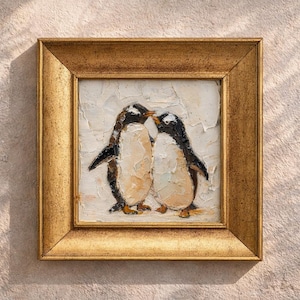 May include: Square framed painting featuring two penguins in a tender embrace. The artwork uses a palette of black, white, and beige, with a textured, impasto style. The frame is a warm gold color, adding to the piece's classic appeal.