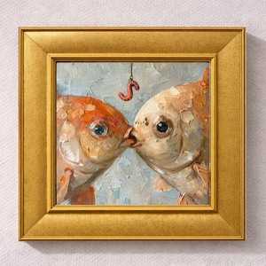 May include: A framed painting depicts two goldfish kissing, with a red worm dangling above them. The artwork features a gold frame and a light blue and white background. The fish are painted in shades of orange and white.