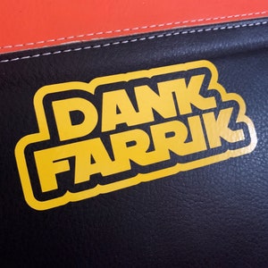 May include: Yellow sticker with the text "DANK FARRIK" on a black leather surface.