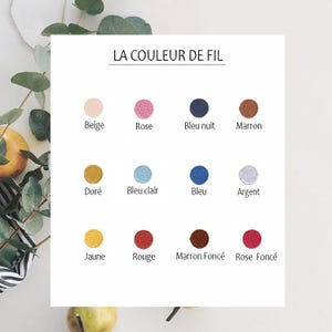 May include: A chart showing 12 different thread colors with their French names. The colors are beige, pink, blue, brown, gold, light blue, dark blue, silver, yellow, red, dark brown, and dark pink.