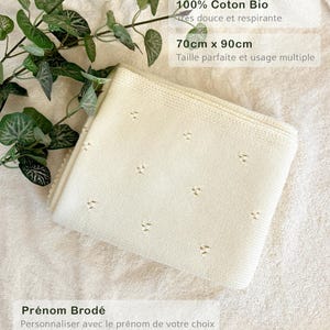 May include: A white knitted baby blanket with a small diamond pattern. The blanket is made of 100% organic cotton and measures 70cm x 90cm. The text "Pr&eacute;nom Brod&eacute;" is printed on the bottom of the image, which translates to "Embroidered Name".