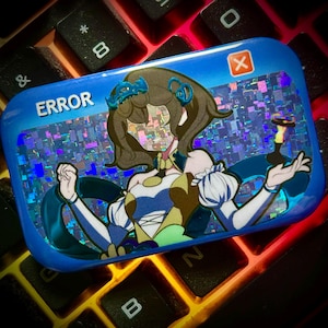 Può includere: Una spilla rettangolare blu con la scritta "ERROR" e una grafica di un personaggio con effetto glitch. La spilla presenta uno sfondo olografico e un simbolo "X" rosso nell'angolo. La spilla è appoggiata su una tastiera.