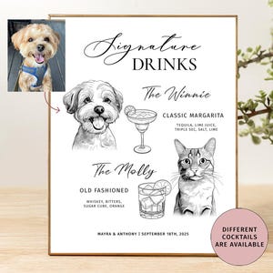 Puede incluir: Un letrero enmarcado blanco con las palabras "Signature Drinks" e ilustraciones de un perro y un gato. El letrero enumera dos recetas de cócteles: una Margarita clásica y un Old Fashioned. También está presente el texto "Different Cocktails Are Available".