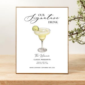 Pu&ograve; includere: Un cartello rettangolare con cornice dorata che presenta il testo OUR SIGNATURE DRINK, un'illustrazione ad acquerello di un margarita con una fetta di lime e il testo The Winnie, CLASSIC MARGARITA, TEQUILA, LIME JUICE, TRIPLE SEC, SALT, LIME, MAYRA & ANTHONY | SEPTEMBER 18TH, 2025.